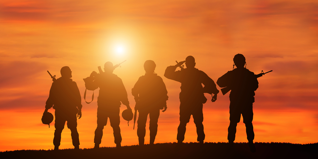 veterans saluting at sunset